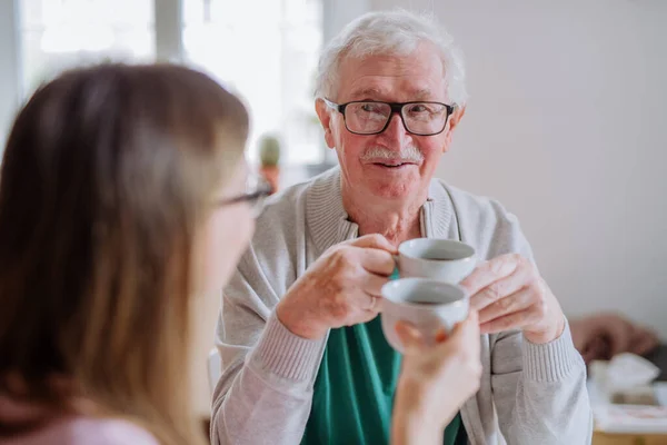 Yetişkin kız, büyük babasını evde ziyaret ediyor, birlikte kahve içiyor, konuşuyor.. — Stok fotoğraf