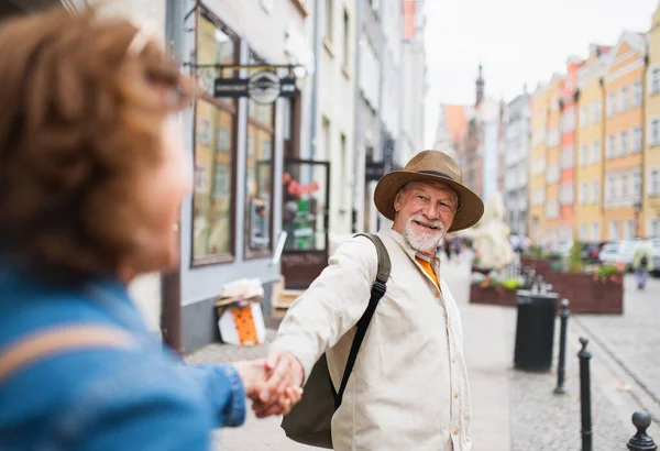 Ευτυχισμένη ηλικιωμένη γυναίκα που δίνει το χέρι της στον ηλικιωμένο άντρα, ερωτευμένο ζευγάρι που κρατιέται έξω στην πόλη — Φωτογραφία Αρχείου