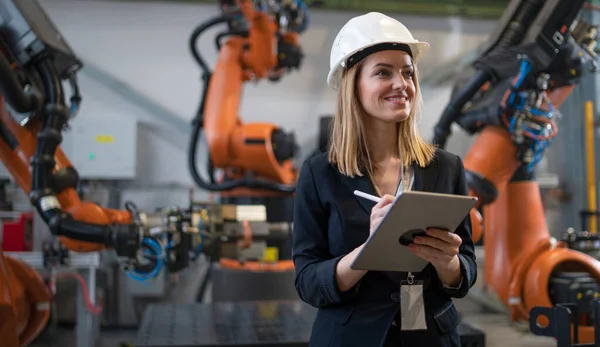 Ingénieur en chef féminin dans l'usine industrielle moderne utilisant la tablette et faisant l'audit. — Photo