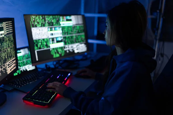 Młoda kobieta haker przez komputer w ciemnym pokoju w nocy, koncepcja cyberwojny. — Zdjęcie stockowe