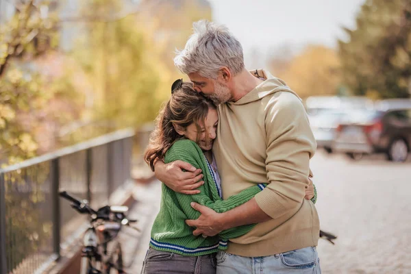 Tiener dochter knuffelen haar vader buiten in de stad bij het doorbrengen van tijd samen. — Stockfoto