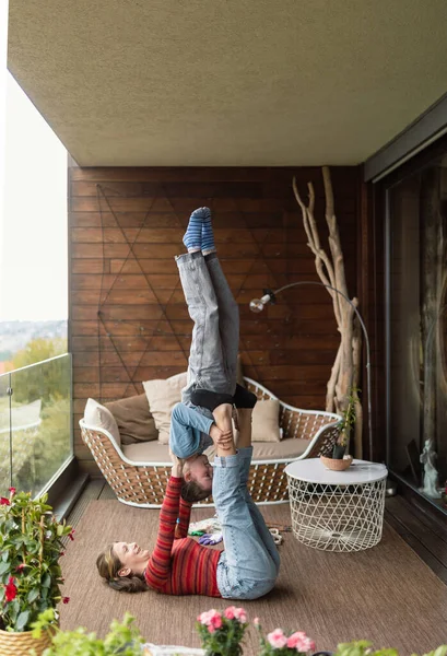 Two little sisters doing acrobatic exercise together at home on balcony. — Fotografia de Stock