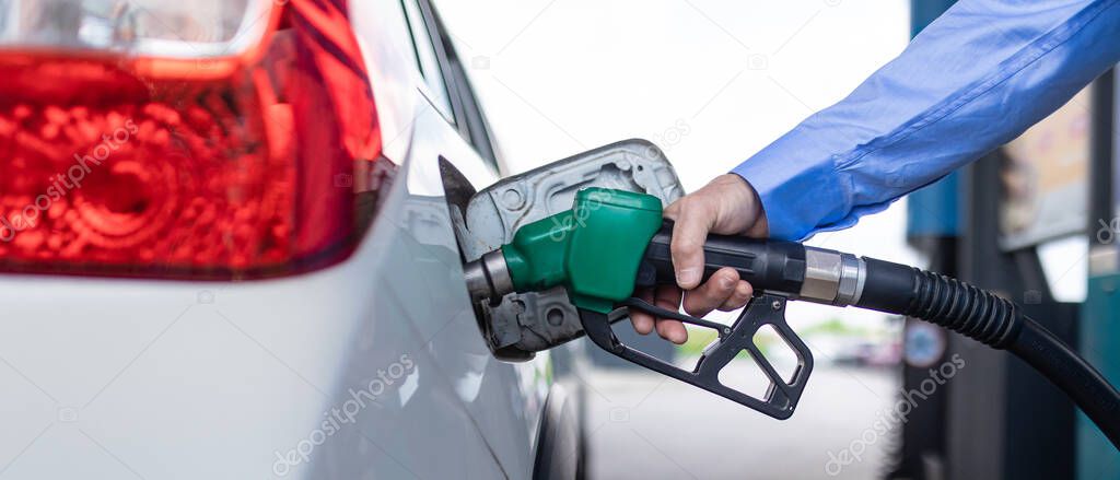 Hand refilling the car with fuel at the refuel station