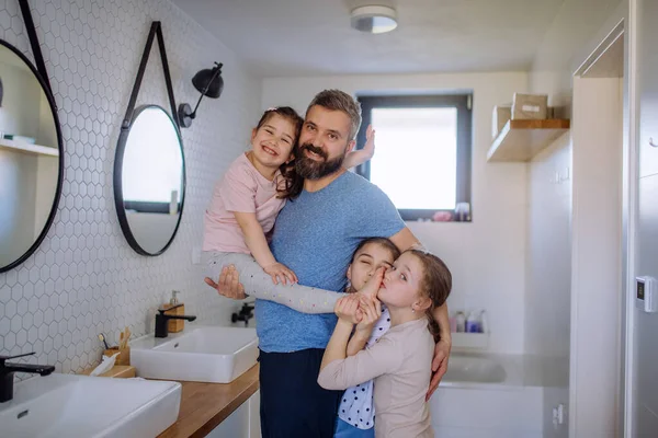 Ο πατέρας δένεται με τις τρεις κόρες του στο μπάνιο και κοιτάζει την κάμερα.. — Φωτογραφία Αρχείου