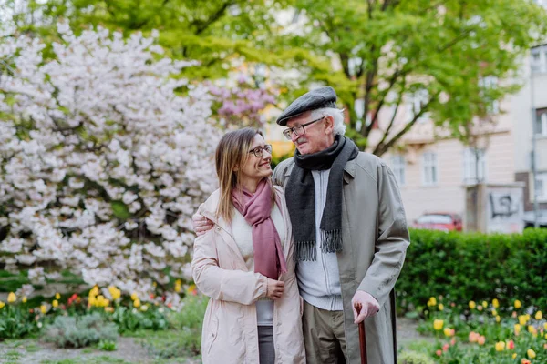 Heureux homme âgé avec bâton de marche et fille adulte à l'extérieur sur une promenade dans le parc. — Photo