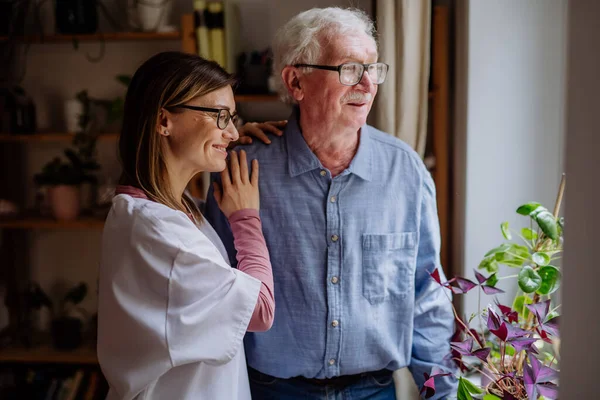 Operatore sanitario o caregiver visita uomo anziano in casa, parlando. — Foto Stock