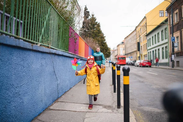 Батько бере свою маленьку дочку з синдромом Дауна до школи, на відкритому повітрі на вулиці . — стокове фото