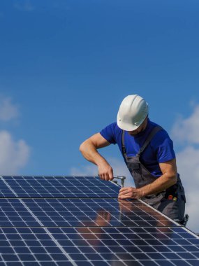 Çatıya güneş fotovoltaik panelleri kuran insan işçisi, alternatif enerji kavramı.