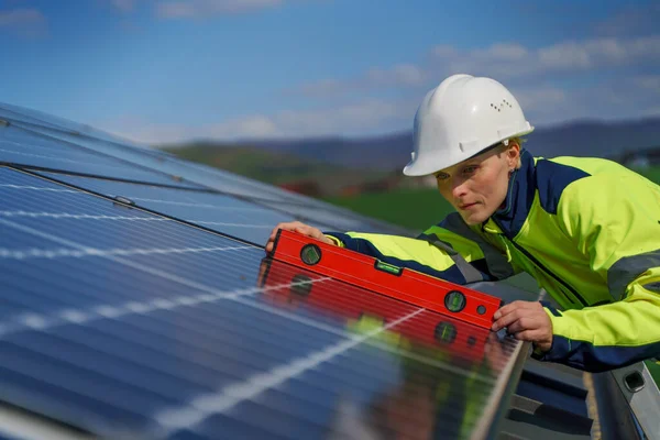 Woman engineer installing a solar photovoltaic panels on roof, alternative energy concept. — Zdjęcie stockowe