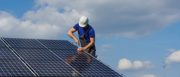 Man worker installing solar photovoltaic panels on roof, alternative energy concept. — 图库照片