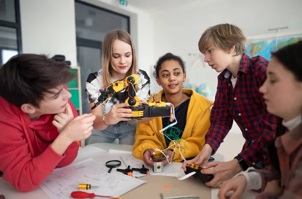 ロボット教室で電気玩具やロボットを構築・プログラミングする学生グループ — ストック写真
