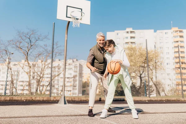 행복 한 아버지와 십 대딸 이 바깥 뜰에서 농구를 하는 모습. — 스톡 사진