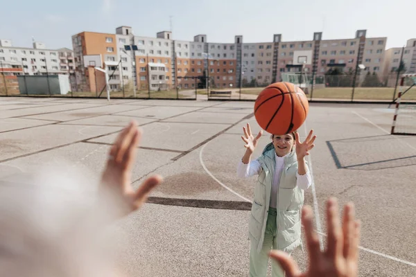 Happy father and teenage daughter playing basketball outside at court. — ストック写真