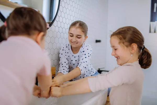 Tres hermanas pequeñas lavándose las manos en el baño, concepto de rutina matutina. —  Fotos de Stock