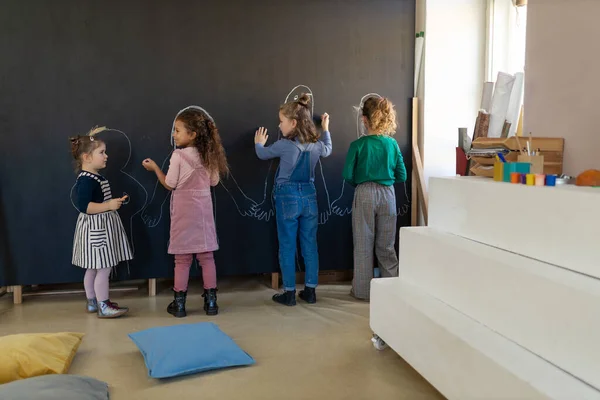 Группа Маленьких Девочек Позирует Перед Школьной Стеной Картины Помещении Игровой — стоковое фото