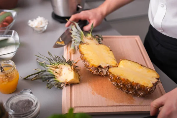 Ein Unkenntlich Gemachter Mann Schneidet Eine Ananas Auf Einem Schneidebrett — Stockfoto