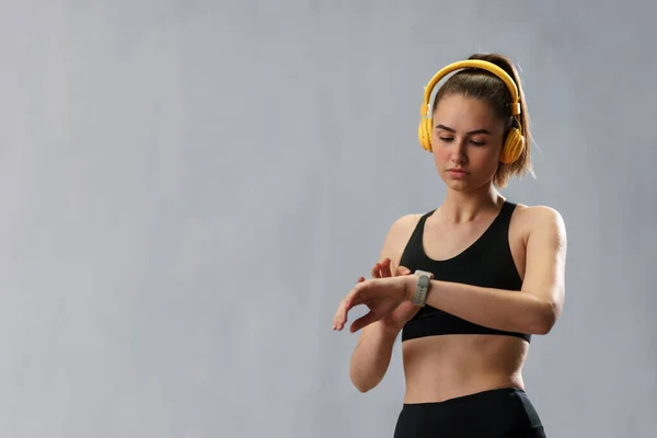 Een Fitnessvrouw Ontspannen Luisteren Muziek Tijdens Haar Training Grijze Achtergrond — Stockfoto