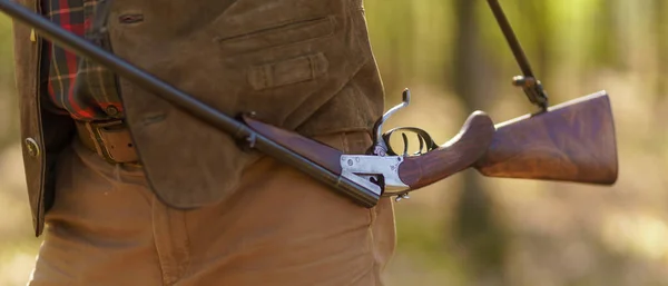 Närbild av jägare man som bär sitt gevär i skogen. — Stockfoto