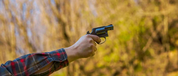 Nerozpoznatelný muž s revolverem mířící na střelnici trénink venku. — Stock fotografie