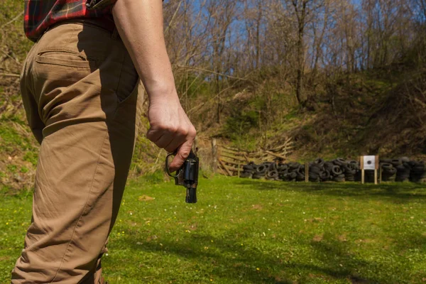Homme méconnaissable avec revolver se préparant à tirer sur la cible sur le champ de tir à l'extérieur. — Photo
