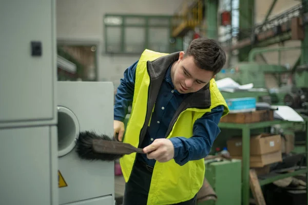 Молодой Человек Синдромом Дауна Работает Промышленной Фабрике Очищает Рабочее Место — стоковое фото