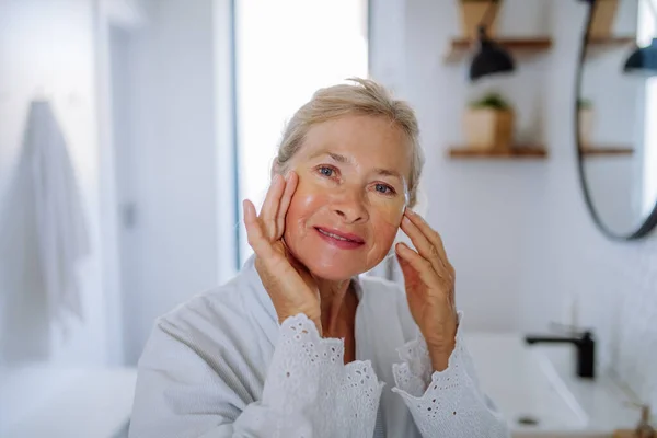 Eine Schöne Seniorin Bademantel Die Augenklappen Gegen Schwellungen Aufträgt Während — Stockfoto