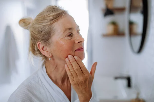 Beautiful Senior Woman Bathrobe Looking Mirror Applying Natural Face Cream — Stok Foto