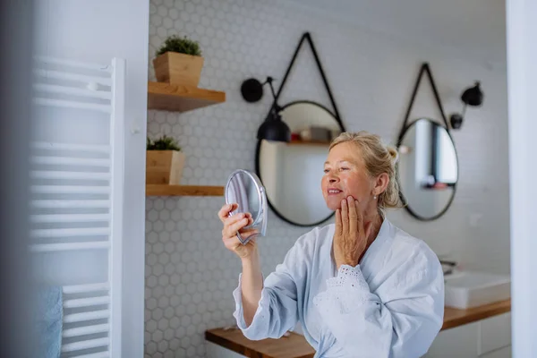 Vacker Senior Kvinna Badrock Tittar Spegel Och Tillämpa Naturlig Ansiktskräm — Stockfoto