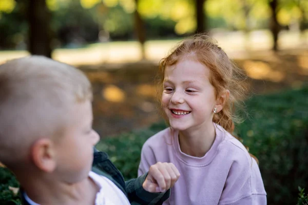 幸せな女の子ですそばかすと赤い髪を持つ楽しいです彼女の兄と笑顔屋外で公園 — ストック写真