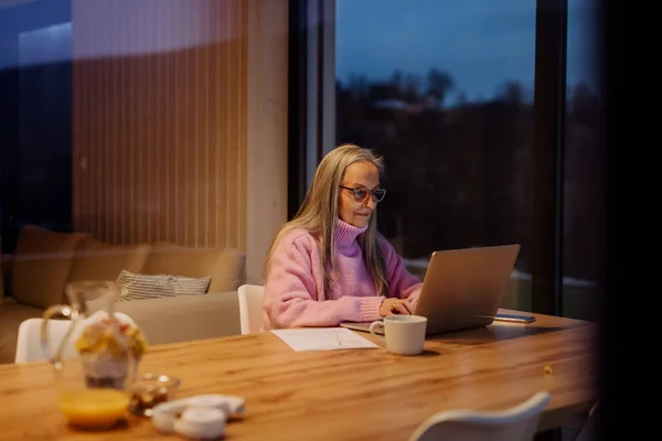 Старшая Женщина Сидит Помещении Работает Laptop View Через Окно — стоковое фото