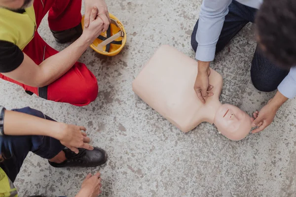 A top view of male instructor showing first medical aid on doll during training course indoors