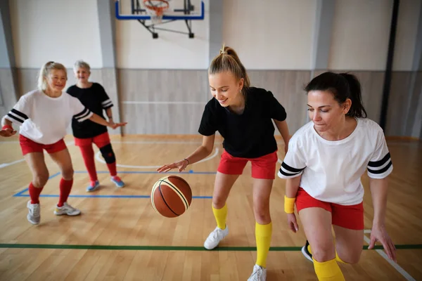 在体育馆打篮球的年轻和年长的妇女 — 图库照片