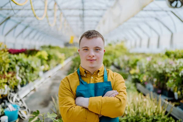 Sendromlu Genç Bir Çalışan Bahçe Merkezinde Çalışıyor Kollarını Kavuşturmuş Kameraya — Stok fotoğraf