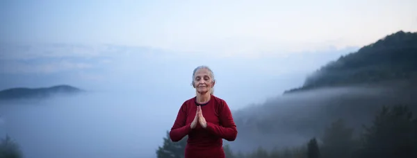 Старша Жінка Робить Дихальні Вправи Природі Рано Вранці Туманом Горами — стокове фото