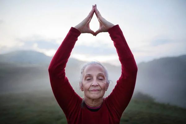 Старшая Женщина Делает Дыхательные Упражнения Природе Рано Утром Туманом Горы — стоковое фото