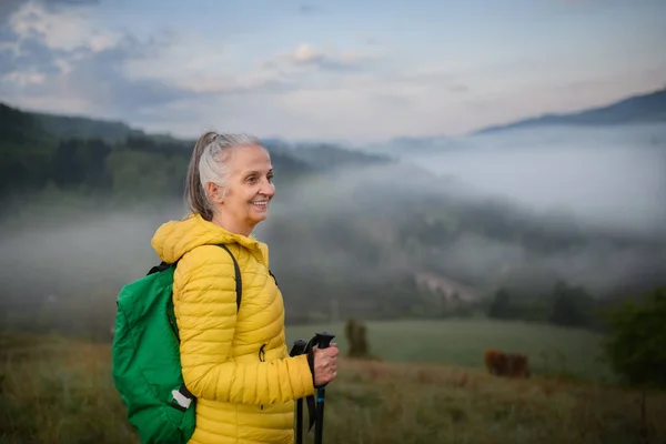 一位老年妇女在大自然中远足 背负着浓雾和群山 — 图库照片