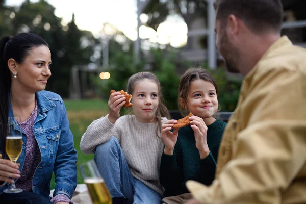 毛布の上に座ってレストランエリアで屋外でピクニックをしている幸せな若い家族 — ストック写真