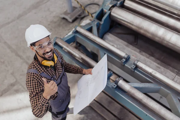 具有安全耳机和硬礼帽的重工业工人手握蓝图的高视角 — 图库照片