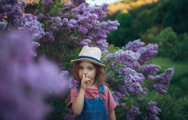 一个在自然界中快乐的小女孩的画像 绽放着淡紫色的草地 她的手指伸进了鼻孔 — 图库照片