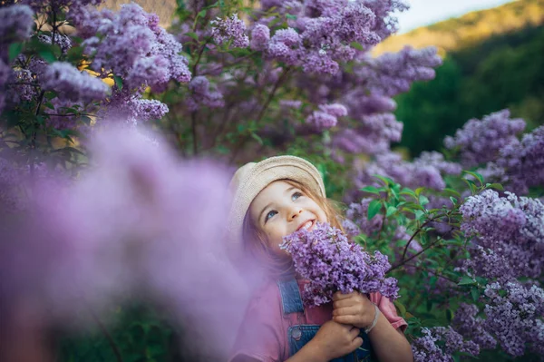 自然の中で陽気な女の子の肖像画ライラック紫の牧草地を開花 — ストック写真