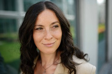 İşe giden bir kadının yakın plan çekimi. Başarılı, mutlu bir iş kadını sabah şehir sokaklarında işe gidip geliyor..