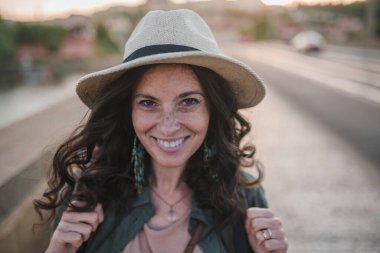 Güneşli bir günde, sırt çantalı genç ve güzel bir bayan gezgin köprüde yürüyor..