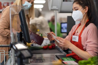 Bir kasiyer, süpermarkette müşterilerin şikayeti üzerine ödeme makbuzu istiyor.,