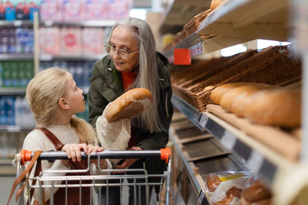 Grootmoeder Met Kleindochter Kiest Koopt Brood Supermarkt — Stockfoto
