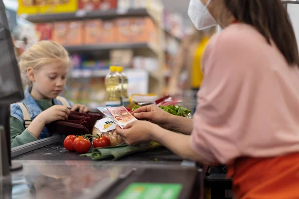 スーパーマーケットでの食料品の買い物のために支払う小さなブロンドの女の子のクローズアップ — ストック写真