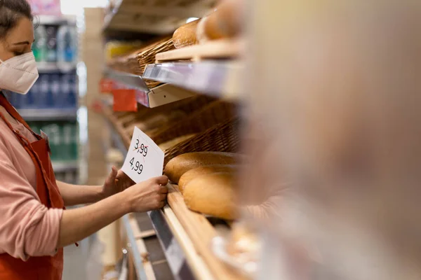 Woman Shop Assistant Changing Prices Bread Supermarket Concept Increasing Inflation — Zdjęcie stockowe