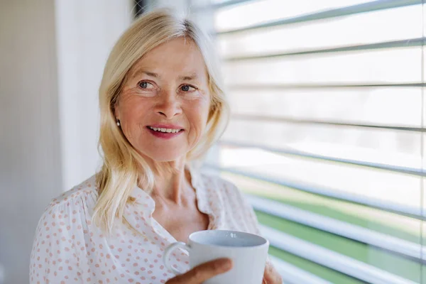 Attractive Senior Woman Drinking Tea Standing Window Home — Foto de Stock