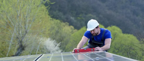 屋根の上に太陽光発電パネルを設置する男労働者 代替エネルギーコンセプト — ストック写真