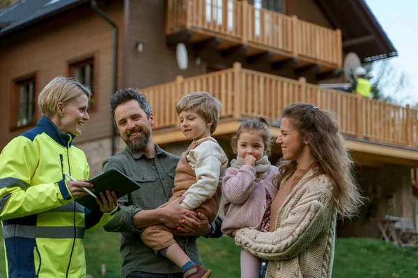 Kvinnlig Ingenjör Pratar Med Ung Familj Solpanelinstallation Framför Deras Hus — Stockfoto