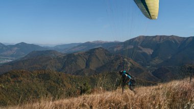 Bir paraglider mavi gökyüzüne doğru iniyor..